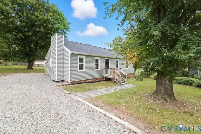 a view of a house with backyard and a tree