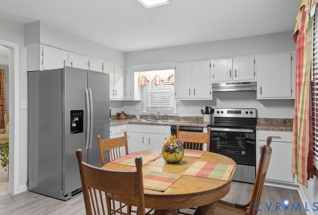 3403 Fallbrooke Court North Chesterfield, VA 23235 - Photo 8 of 23 a kitchen with a refrigerator a stove a sink dishwasher a dining table and chairs with wooden floor