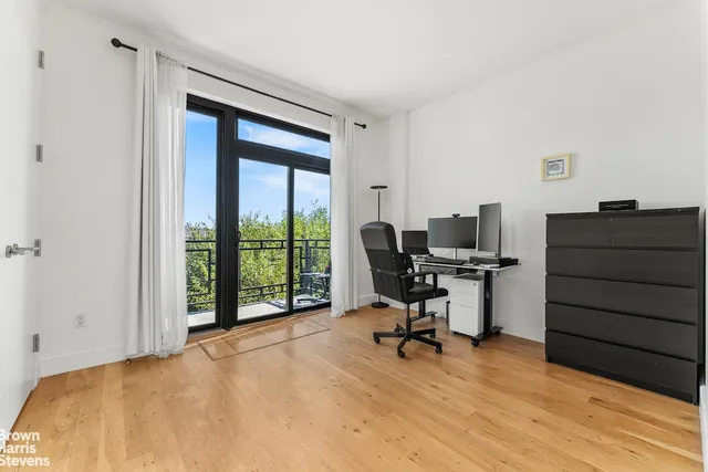 a view of a workspace with furniture and a window