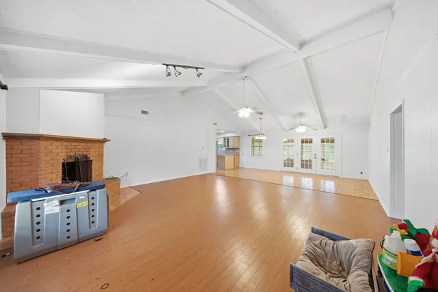 a view of an empty room with a window and fireplace