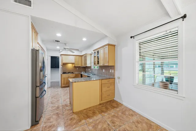 a kitchen with stainless steel appliances granite countertop a refrigerator and a stove top oven