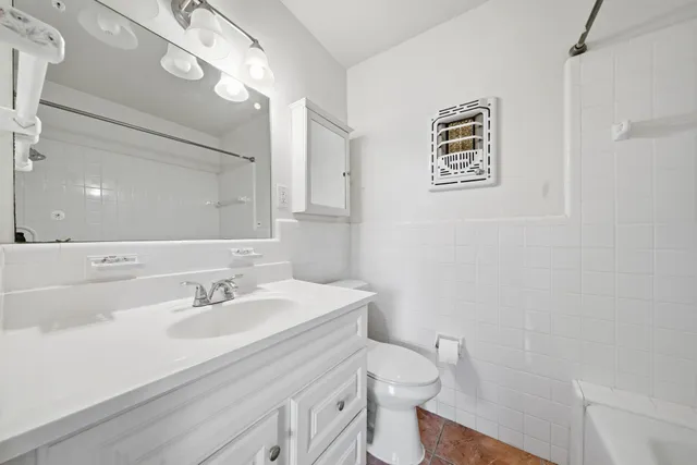 a bathroom with a sink a toilet a mirror and shower