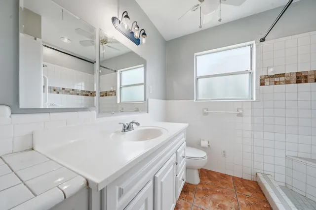 a living room with furniture large windows and wooden floor