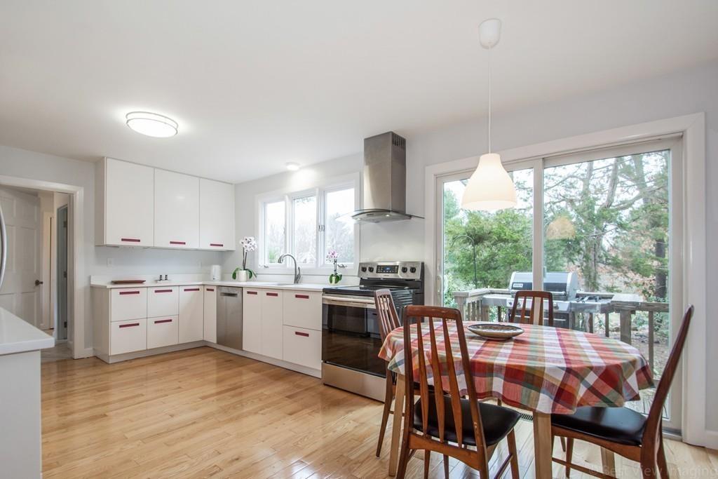 51 Cobleigh Road Boxborough, MA 01719 - Photo 7 of 32 a kitchen with a stove a sink a dining table and chairs