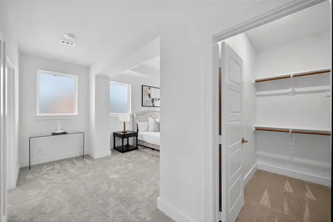 a spacious bedroom with a bed and a lamp