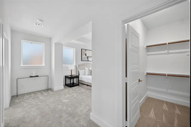 a spacious bedroom with a bed and a lamp