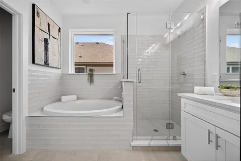 a spacious en suite bathroom with double sink and a mirror