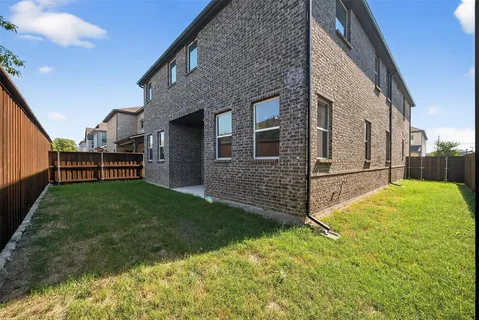 a view of a house with a yard and wooden fence