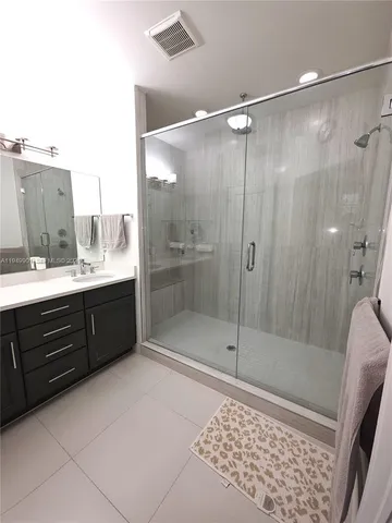 a bathroom with a shower sink and mirror