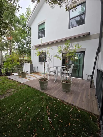 a view of a patio with table and chairs potted plants and large tree