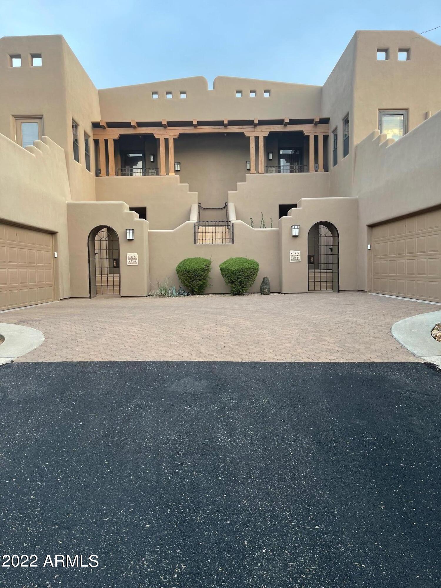 36601 North Mule Train Road, Unit A23 Carefree, AZ 85377 - Photo 21 of 26 a front view of a house with a yard and garage