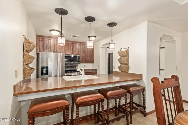 a kitchen with stainless steel appliances granite countertop table chairs and chandelier