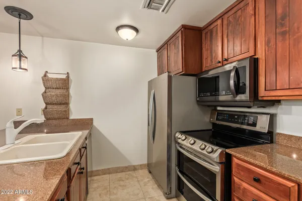 a kitchen with stainless steel appliances granite countertop a sink stove and refrigerator