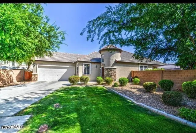 a front view of a house with a garden and yard