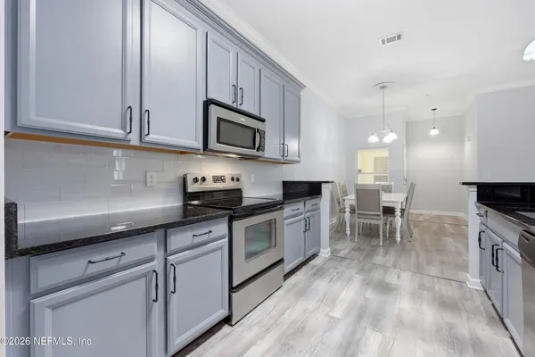 a kitchen with stainless steel appliances granite countertop a stove a sink a microwave and cabinets