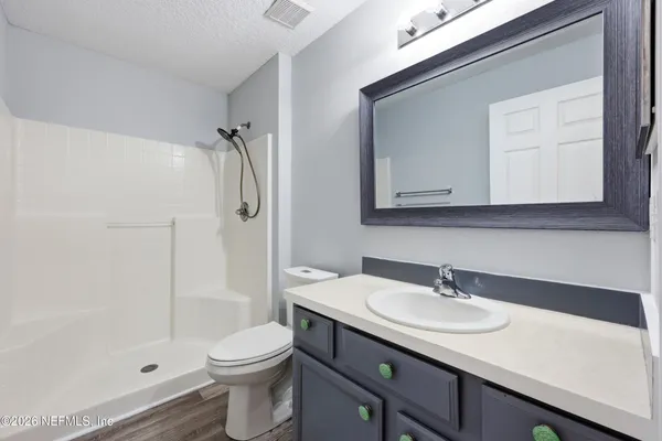 a bathroom with a sink a toilet and shower