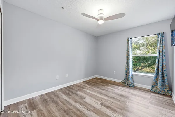 an empty room with wooden floor and windows