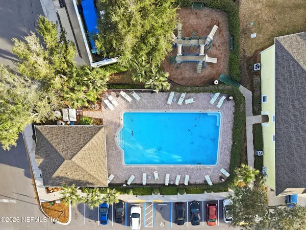 an aerial view of a house with swimming pool and outdoor seating