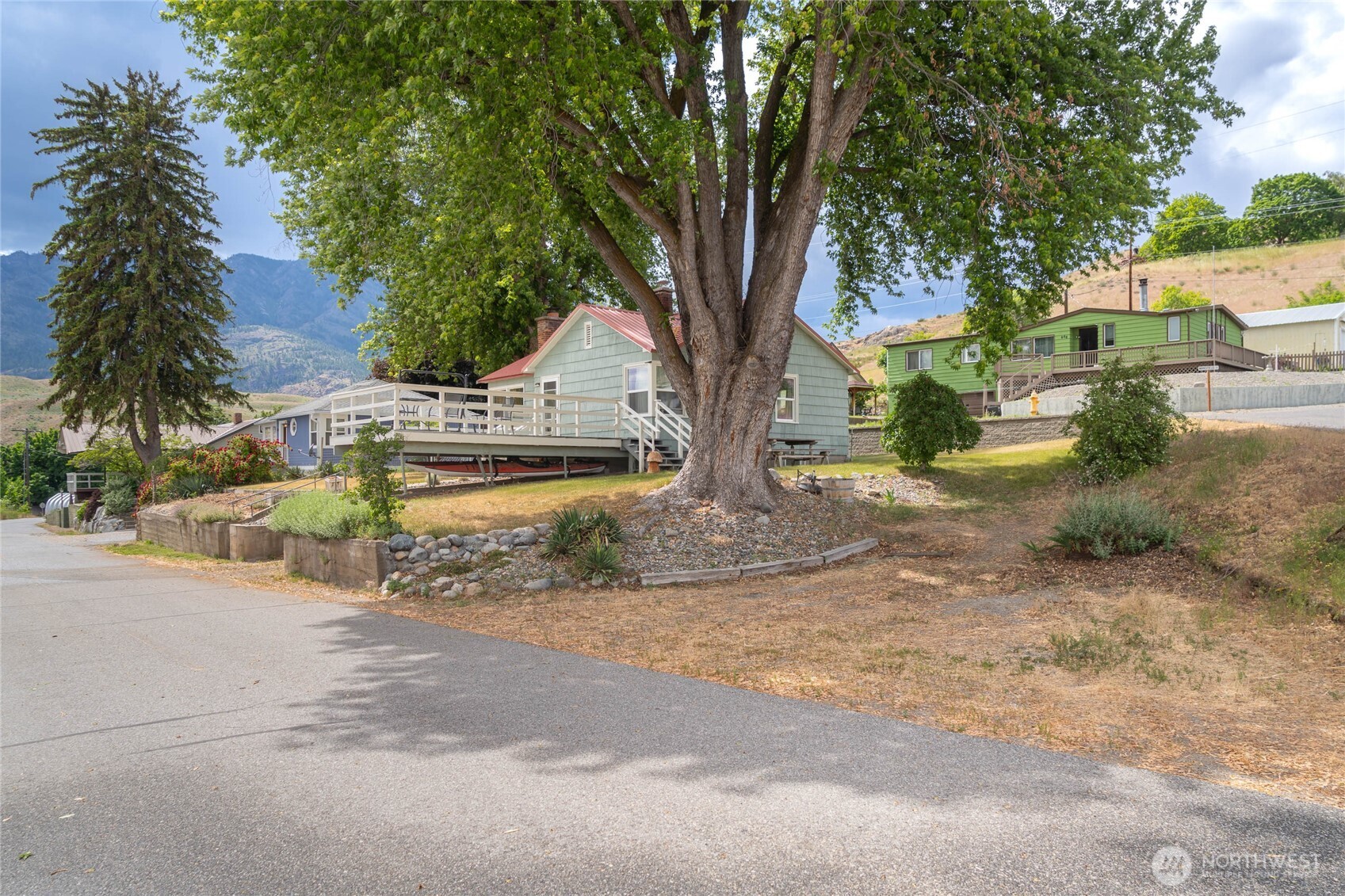 462 Beach Street Pateros, WA 98846 - Photo 2 of 30 a view of a yard with plants and a large tree