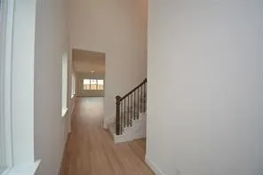 a view of a hallway with wooden floor and entryway