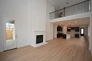 a view of an empty room with wooden floor fireplace and windows