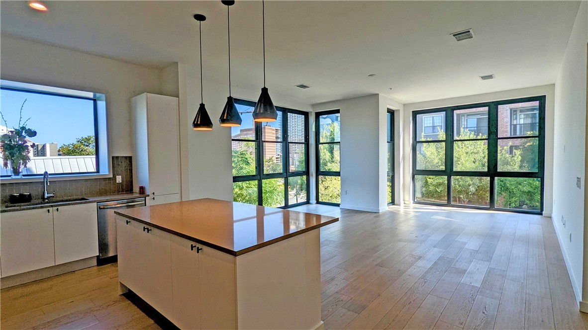 a kitchen with stainless steel appliances granite countertop a sink and a large window