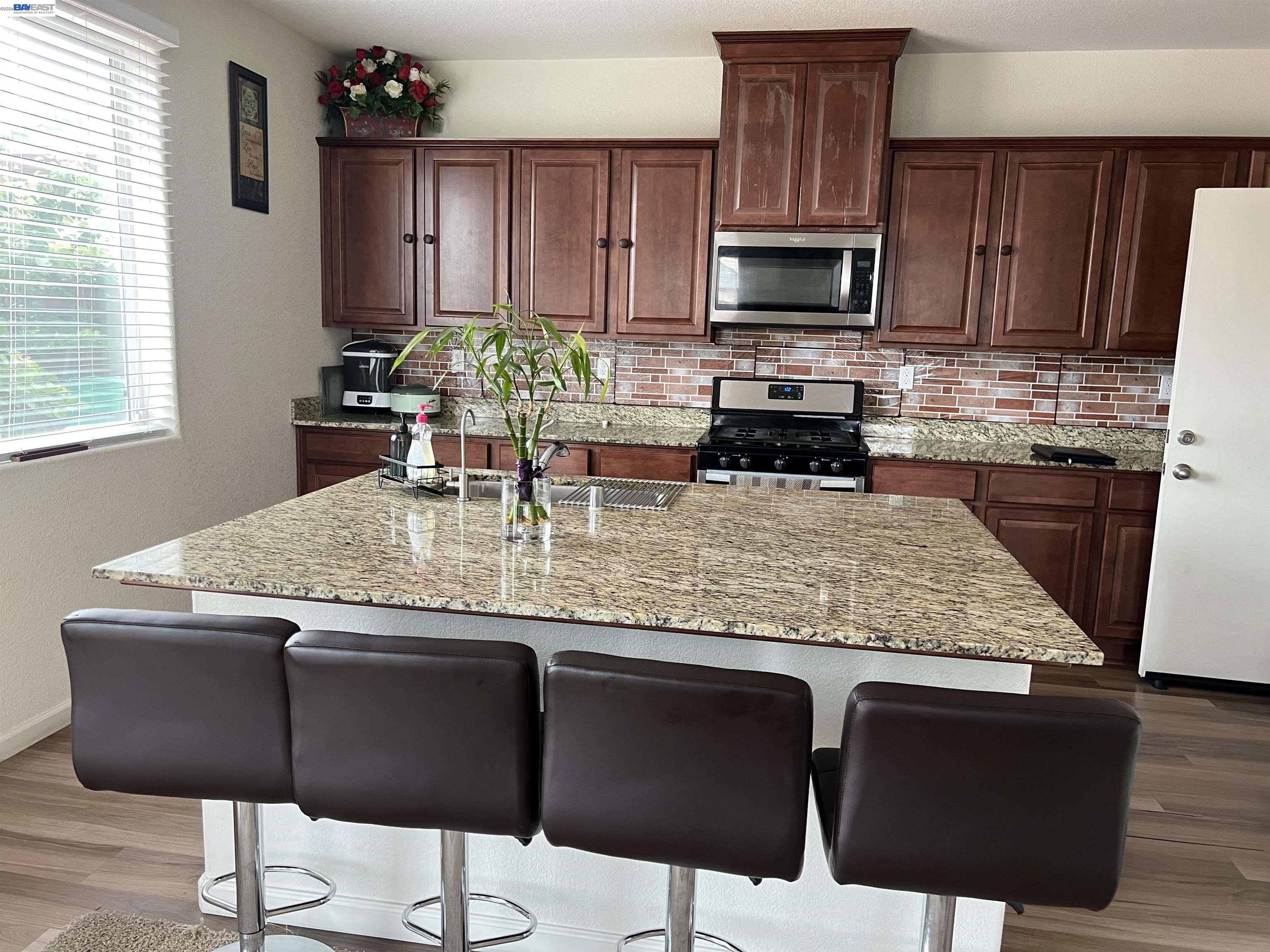 3319 Seger Way Stockton, CA 95212 - Photo 7 of 9 a kitchen with granite countertop wooden cabinets dining table and chair