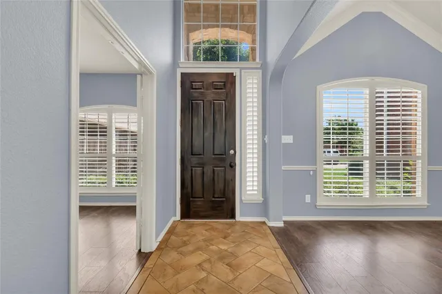 a view of a hallway with windows and a room