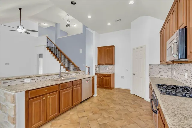 a kitchen with granite countertop a sink stove and cabinets