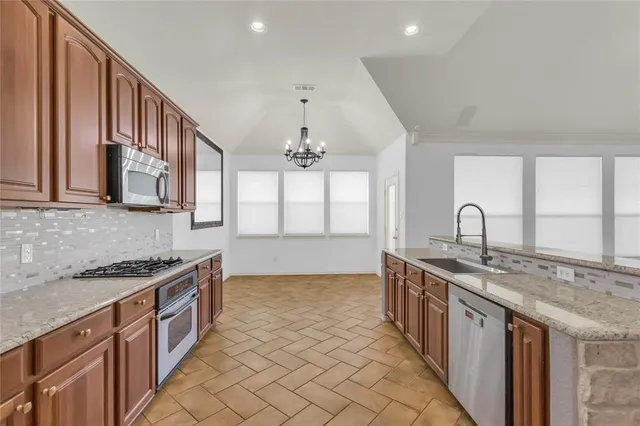 a kitchen with stainless steel appliances granite countertop a sink stove and cabinets