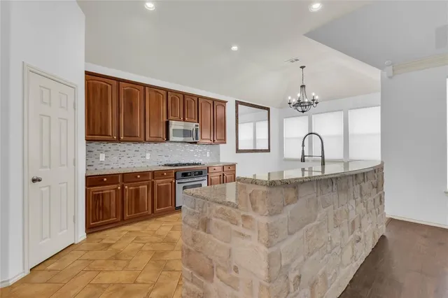 a kitchen with stainless steel appliances granite countertop a sink stove and cabinets