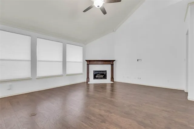 wooden floor fireplace and windows in an empty room