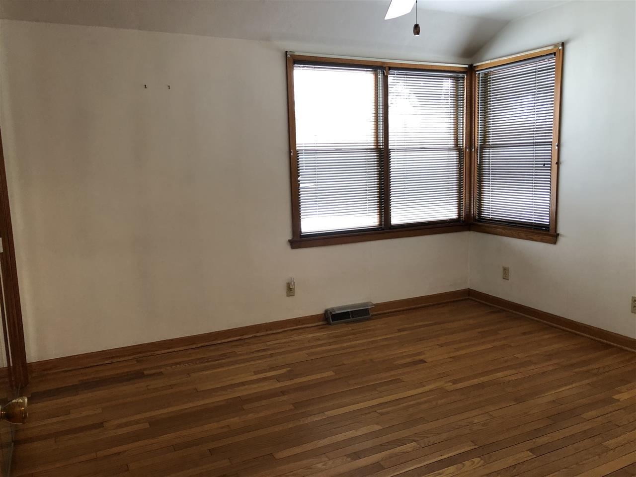 3515 East Oak Grove Road Byron, IL 61010 - Photo 17 of 25 a view of an empty room with wooden floor and a window