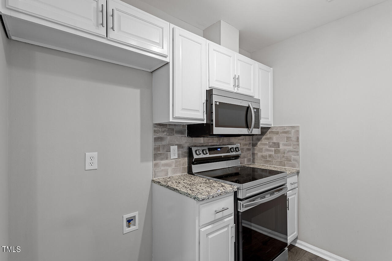 1209 Hazelnut Drive Raleigh, NC 27610 - Photo 4 of 24 a kitchen with stainless steel appliances a stove microwave and sink