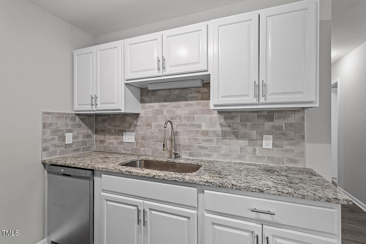 1209 Hazelnut Drive Raleigh, NC 27610 - Photo 6 of 24 a kitchen with granite countertop white cabinets and a white appliances