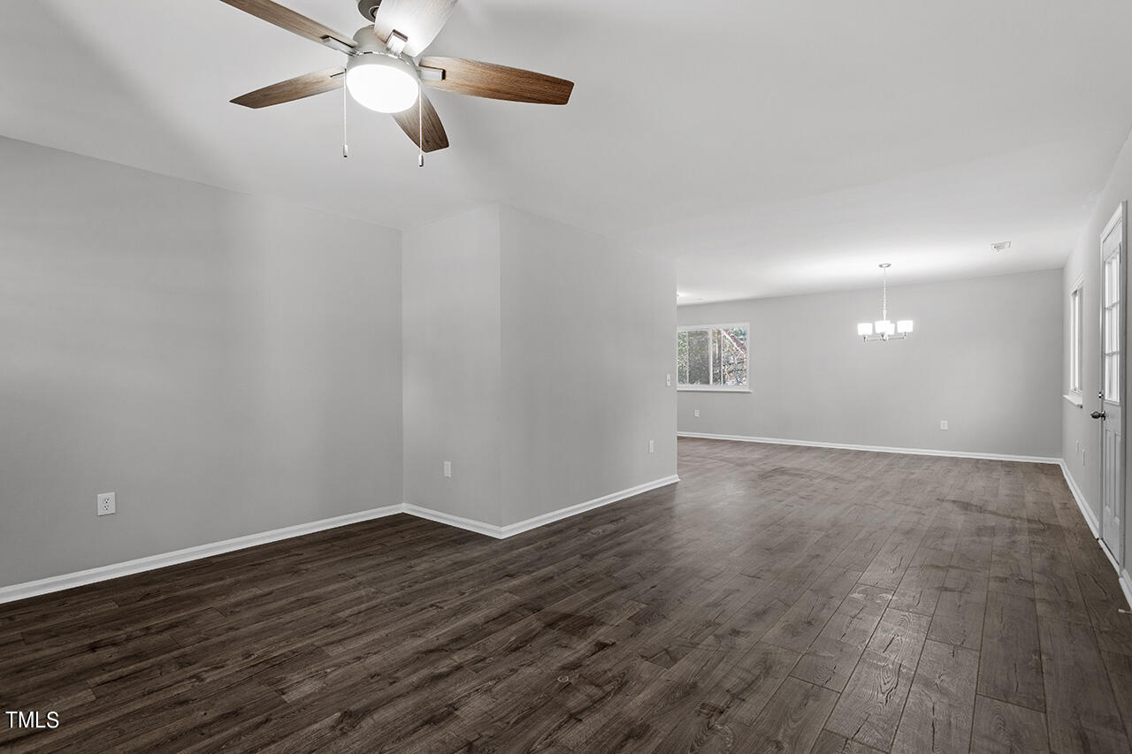 1209 Hazelnut Drive Raleigh, NC 27610 - Photo 9 of 24 a view of an empty room with wooden floor and a ceiling fan