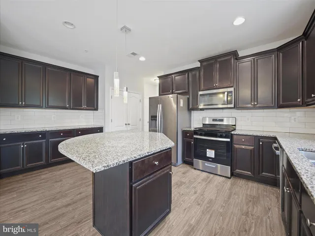 a kitchen with stainless steel appliances granite countertop a stove refrigerator and sink