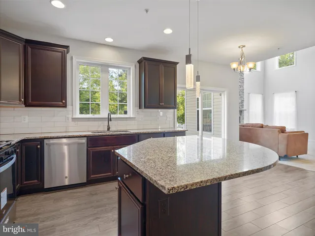 a kitchen with granite countertop a sink a counter space appliances and cabinets