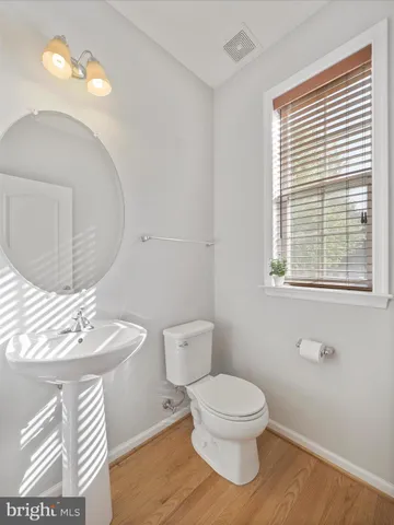 a bathroom with a toilet a sink and mirror
