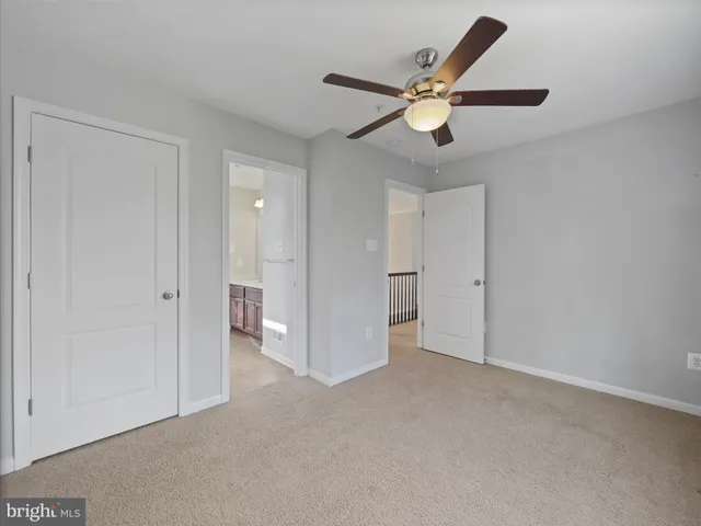 a view of an empty room and chandelier fan