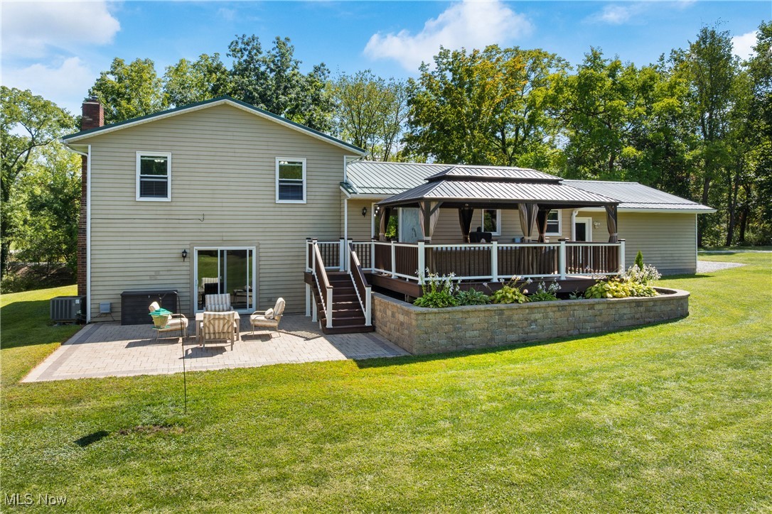 10229 Crawford Road Homerville, OH 44235 - Photo 29 of 42 Back of property with a patio, a yard, a deck, stairway, and a chimney