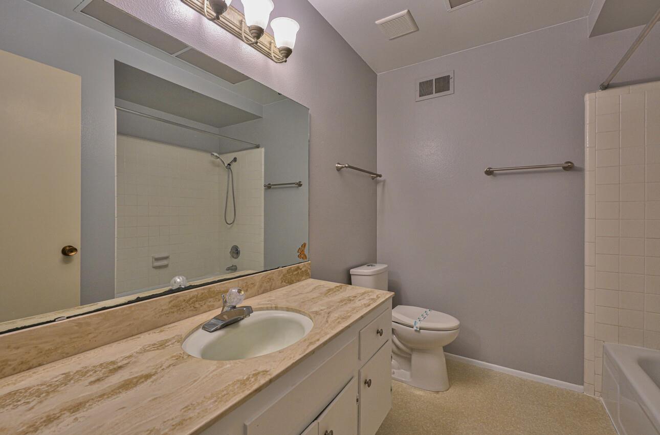23007 Espada Drive Salinas, CA 93908 - Photo 28 of 39 a bathroom with a granite countertop sink a toilet and a mirror