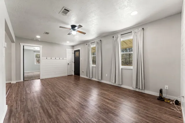 a view of a livingroom with wooden floor and a ceiling fan