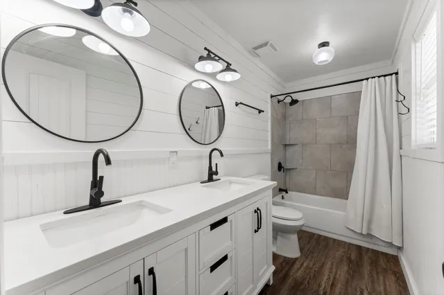 a bathroom with a double vanity sink mirror and toilet