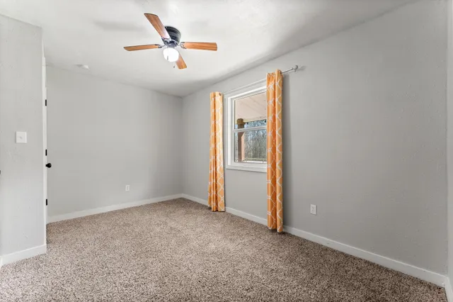 an empty room with closet and fan