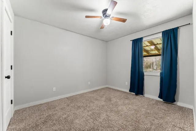 a view of empty room with ceiling fan