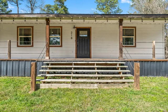 a view of a house with backyard and wooden fence