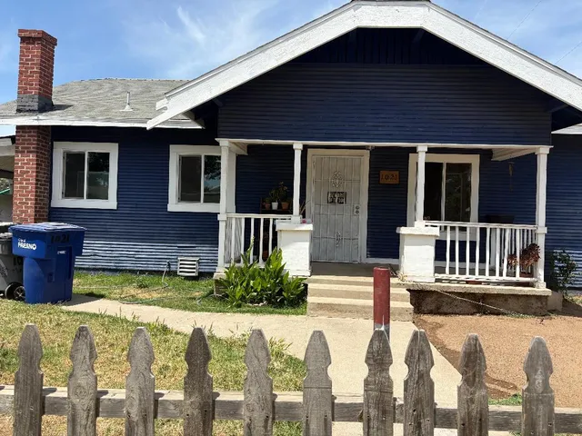 a view of a house with wooden deck and furniture