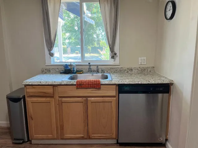 a kitchen with kitchen island granite countertop cabinets and window