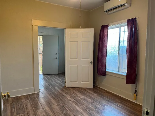 an empty room with wooden floor and closet